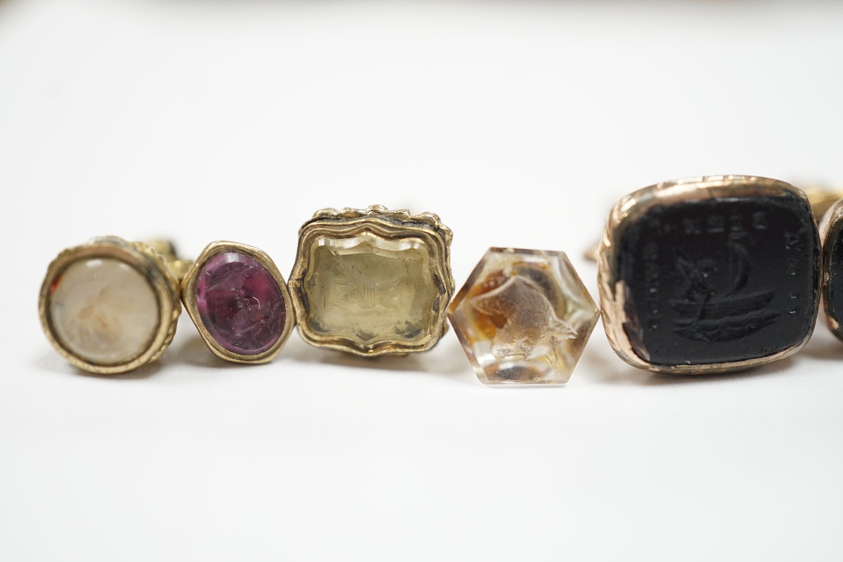 A collection of twelve small 19th century mainly yellow metal fob seals, with assorted matrices including bloodstone, amethyst, citrine and carnelian, largest 22mm.